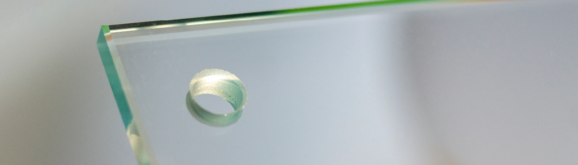 dettaglio di una lastra di materie plastiche trasparenti di Biella Legno con un foro
